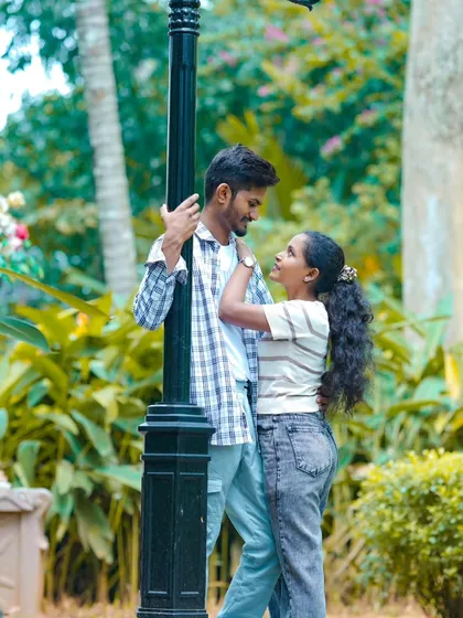 A romantic moment by a lamppost in a park. This classic, sweet pose is perfect for a casual pre-wedding shoot.