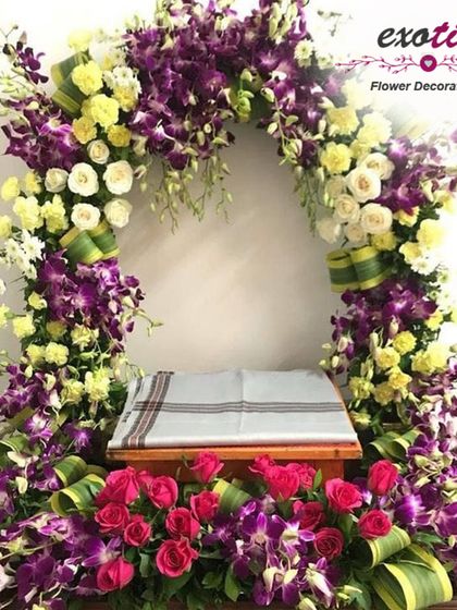 A floral arch for a home deity. We used a vibrant combination of purple orchids, yellow chrysanthemums, and white roses to create a beautiful frame for a small home temple.
