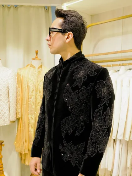 A side profile of the black velvet bandhgala with intricate floral beadwork. The structured fit and detailed craftsmanship create a powerful and elegant silhouette.