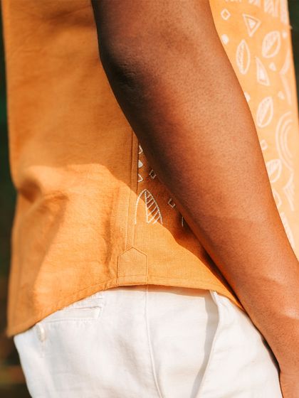 A detail of the gusset on our 'Ferocity' tangerine orange panther shirt. This small touch shows our commitment to durability and quality in every garment we craft.