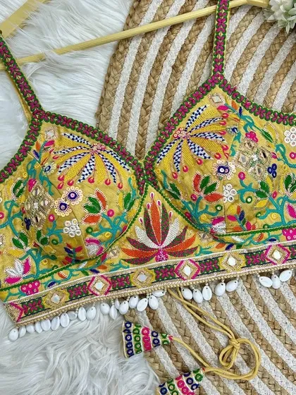 A bright yellow version of my intricately embroidered V-neck blouse. The colorful floral patterns and shell details give it a cheerful and festive feel.