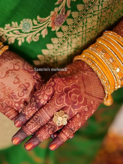 A stunning close-up of the henna stain, paired with bright yellow bangles. The color is deep and vibrant, perfect for a festive occasion.