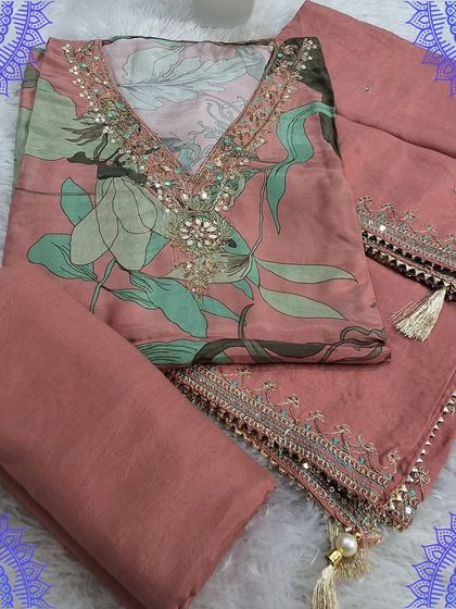 A beautiful unstitched suit set featuring a digital Kalamkari print on the top fabric. The set is complemented by an embroidered dupatta with delicate tassels.