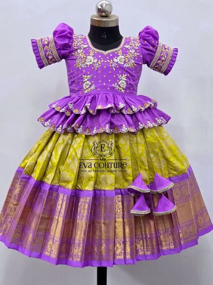A stunning combination of purple and lime green. This lehenga has a tiered peplum blouse with beautiful embroidery and a rich Kanchi Pattu skirt.