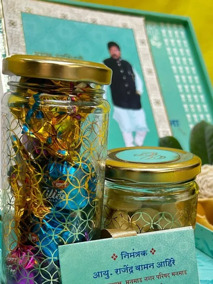 A close-up of the treats inside the hamper. One jar is filled with colorful wrapped chocolates, while the other contains premium dry fruits, showing the variety of gourmet goodies I can include.