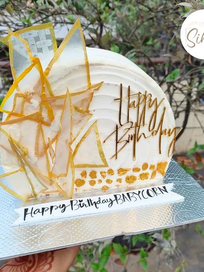 Top forward cakes are a personal favorite. This modern design features shattered rice paper sails with gold accents, creating a unique and artistic architectural look.