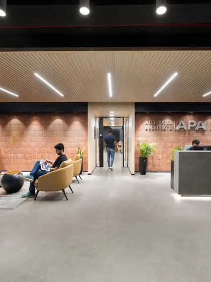 A wider view of the reception lounge, showing how we create different zones for waiting and informal meetings. The yellow sofa adds a pop of color against the neutral, textured background.