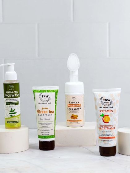 A full range of face wash products is displayed on clean, white risers against a tiled background. This group shot effectively showcases the variety of the product line in a fresh, organized manner.