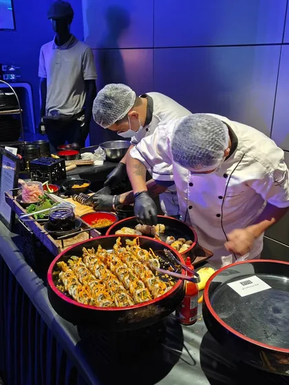 Our sushi chefs meticulously preparing rolls at a live sushi counter. Offering freshly made sushi adds a touch of sophistication and provides a healthy, delicious option for guests at corporate and social events.