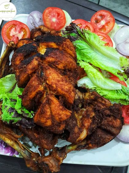 A full chicken roast, served with a fresh salad of lettuce, tomatoes, and onions. A healthy and delicious option for any occasion.