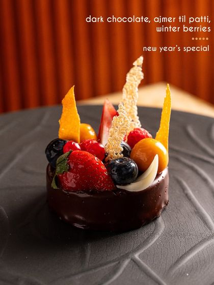 A grand finale for our New Year's feast: a dark chocolate dessert with Ajmer til patti and winter berries.