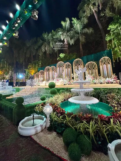 The angelic fountain and topiary garden in front of the stage, adding a touch of European garden elegance to the wedding decor.