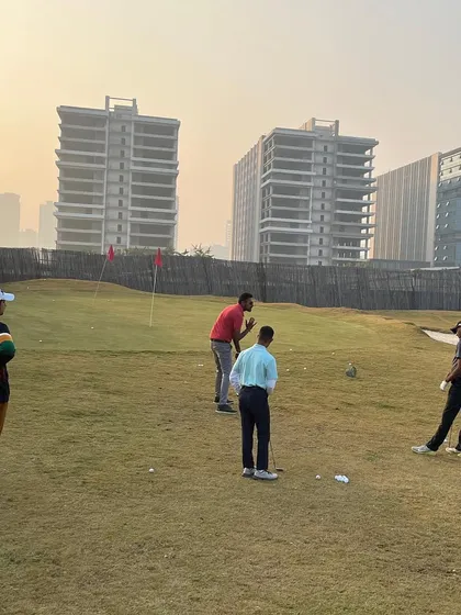 A group of golfers working on their short game. Our facility includes varied terrain to help you practice different types of shots.