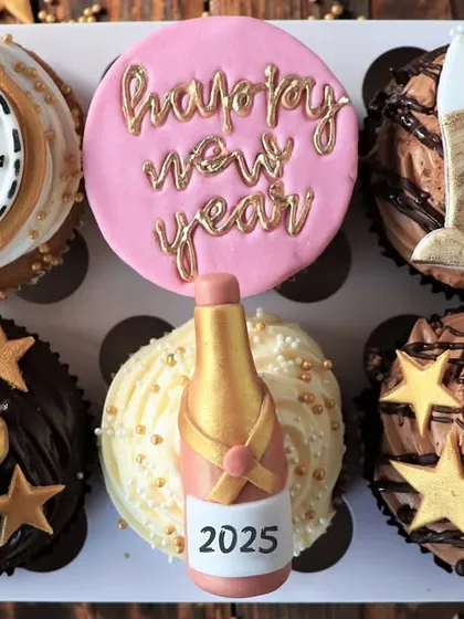 A set of six New Year's Eve cupcakes, decorated with festive designs including a clock striking midnight, a champagne bottle, and golden stars. These are the perfect sweet treat to ring in the new year.