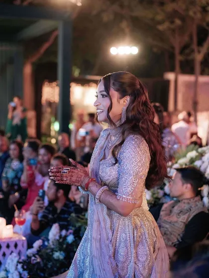 A candid shot of the bride enjoying her sangeet. The makeup is designed to be fun and glamorous, perfect for a night of dancing.