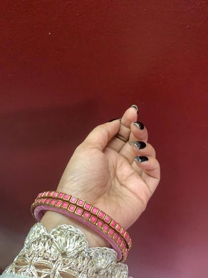 A collection of my pink silk thread bangles, showcasing a variety of designs from simple geometric patterns to elaborate floral kundan work.