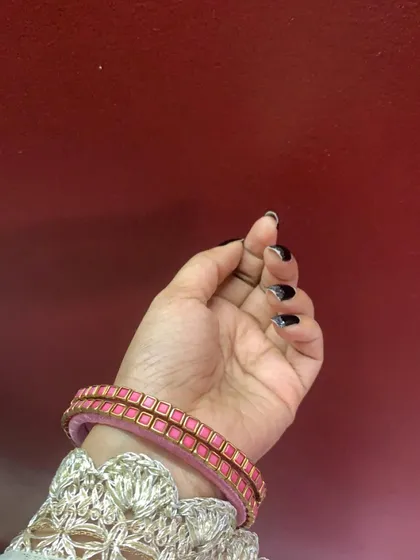 A collection of my pink silk thread bangles, showcasing a variety of designs from simple geometric patterns to elaborate floral kundan work.