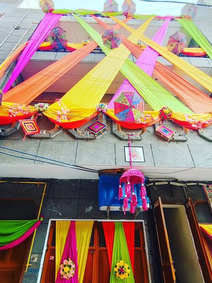 A wide view of the decorated house, with colourful drapes, umbrellas, and tassels creating a rich, layered look.