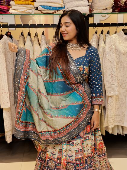 This shot showcases the full skirt of the multi-colored lehenga, allowing you to see the beautiful blend of colors and traditional motifs.