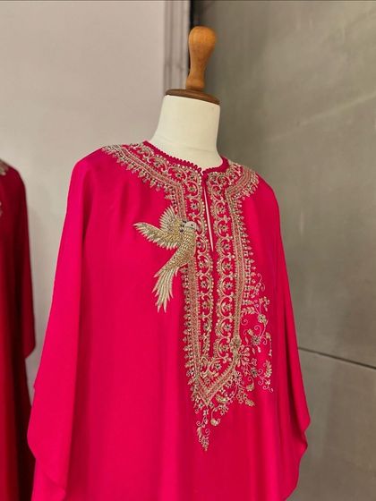 A close-up of a stunning pink kaftan with a beautifully embroidered bird motif, a highlight of our curated Diwali edit.
