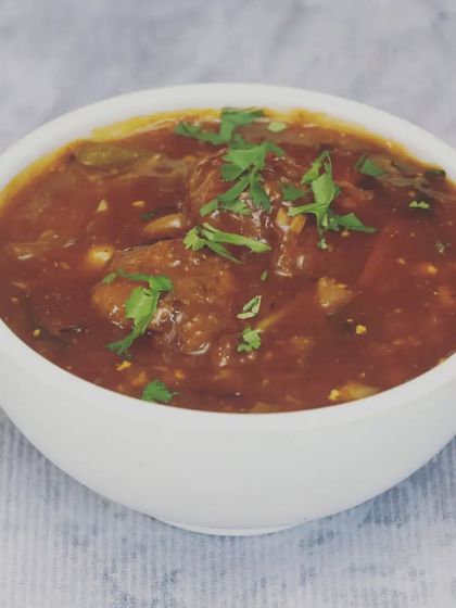 This is my Veg Manchurian, featuring soft vegetable balls in a thick, tangy, and slightly spicy gravy. It's a perfect accompaniment to fried rice or noodles and is garnished with fresh coriander.