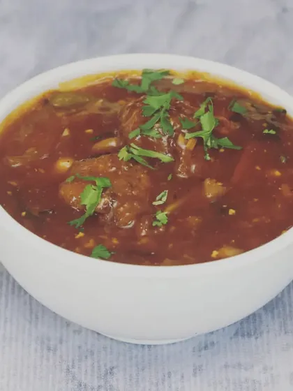 This is my Veg Manchurian, featuring soft vegetable balls in a thick, tangy, and slightly spicy gravy. It's a perfect accompaniment to fried rice or noodles and is garnished with fresh coriander.