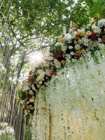 The sun peeking through a lush floral canopy. I love incorporating natural light into my designs, and this angle shows how the sun's rays can add an extra layer of magic to a floral mandap.