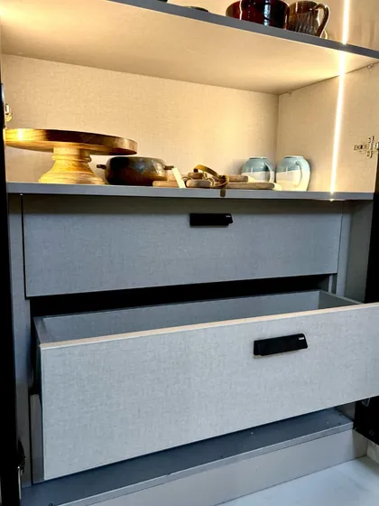 A close-up on the smooth-gliding drawers, built with German hardware for reliability. The textured laminate finish on the drawer fronts adds a subtle touch of sophistication to the overall design.