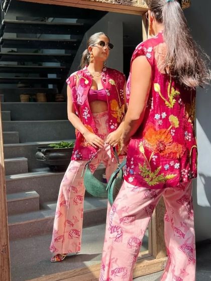 A mirror selfie capturing the Selena in Forest Green. The bag's elegant curve and rich color add a sophisticated touch to a vibrant, patterned outfit.