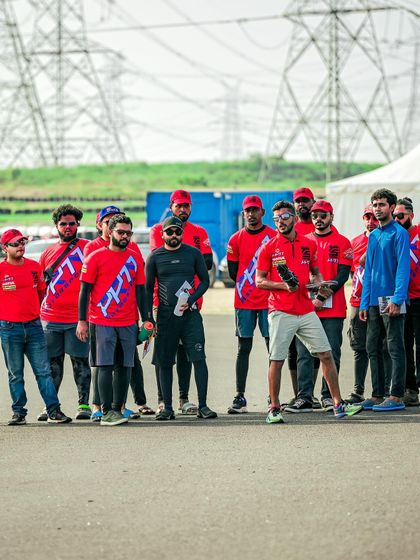 A group of riders and coaches during a track walk. This is a crucial part of our training, where we explain the racing lines, braking markers, and corner apexes before the riding begins.