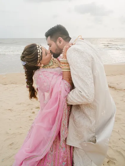 A stolen kiss against the backdrop of the ocean waves in Goa. We specialize in destination weddings, capturing the romance of the location as much as the love between the couple for truly memorable beach wedding photography.