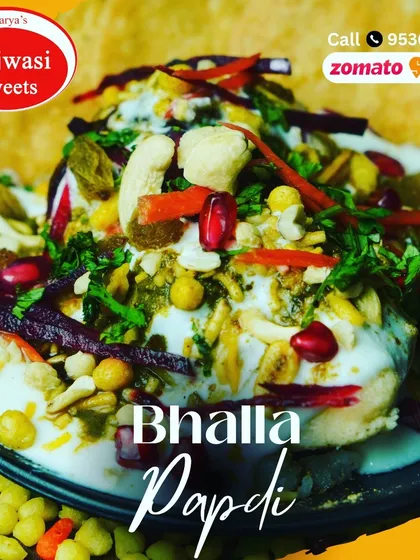 A close-up of my special Bhalla Papdi. It’s a festival of textures and flavors, with soft bhallas, crispy papdi, cool yogurt, and tangy chutneys, garnished with pomegranate and sev.