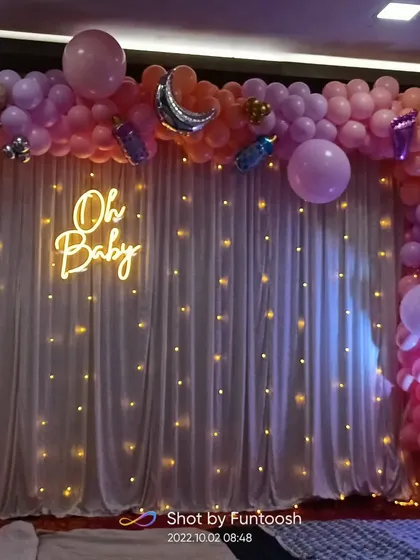 The full balloon arch for the baby shower decor, using a mix of pastel pink, purple, and gold balloons.