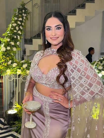 The full look, complete with a sparkling clutch. The mauve tones in her outfit are complemented by the neutral, smokey makeup.