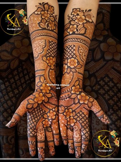 This intricate floral design covers the hands and arms in a dense pattern of flowers and leaves. The combination of bold florals and fine-line details creates a rich and luxurious effect.