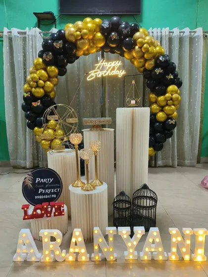 A classic black and gold theme is always a winner. This full balloon ring, accented with butterfly details and a neon sign, creates a glamorous backdrop for Aranyani's birthday celebration.