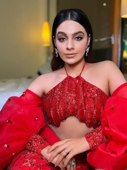 Another indoor portrait, highlighting the unique design of the red halter top and the sparkling diamond earrings I chose.
