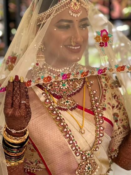 A candid moment of the bride, her smile framed by the delicate, hand embroidered veil. This shows the personal, joyful side of wearing a custom creation on your wedding day.