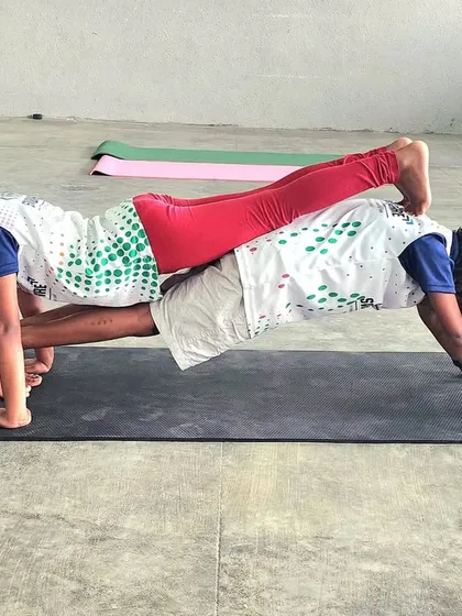 Partner acrobatics are a cornerstone of our camp, teaching children about balance, communication, and mutual support. This double plank pose showcases incredible focus and core strength from our young gymnasts.