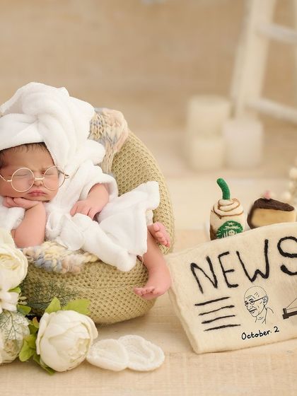 A patriotic and playful theme for a baby born on October 2nd, styled with round glasses and a felt newspaper prop featuring Mahatma Gandhi.