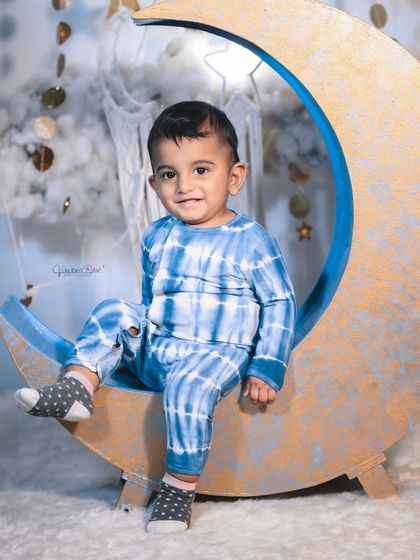 A happy toddler enjoying the celestial moon set. The soft, cloud-like floor is perfect for babies who are sitting or crawling, ensuring they are comfortable throughout the shoot.