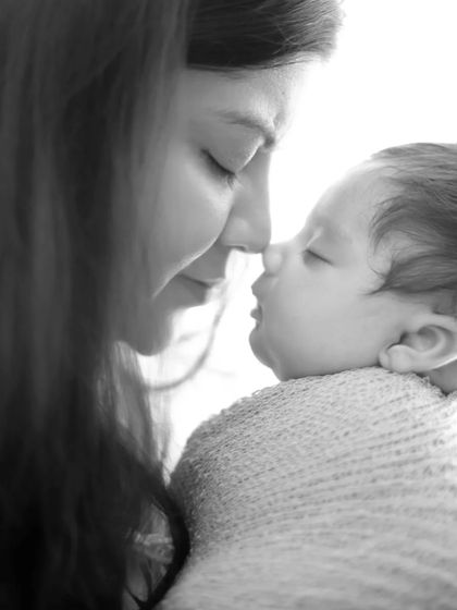 An intimate black and white portrait capturing the tender bond between a mother and her sleeping baby. These quiet moments are priceless.