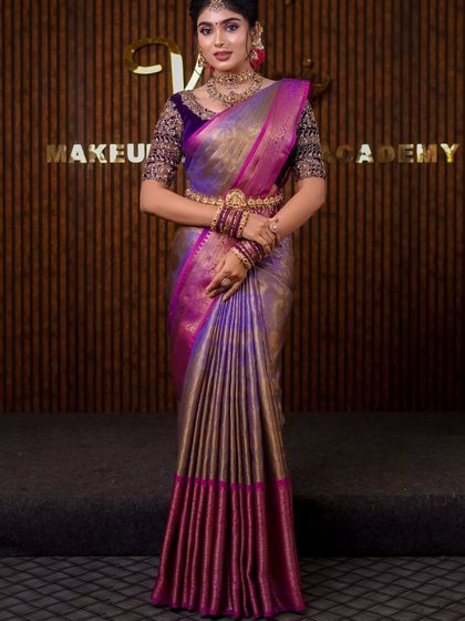 A stunning purple and gold Kanchipuram saree. The draping style is grand and traditional, perfect for a classic bridal photoshoot.