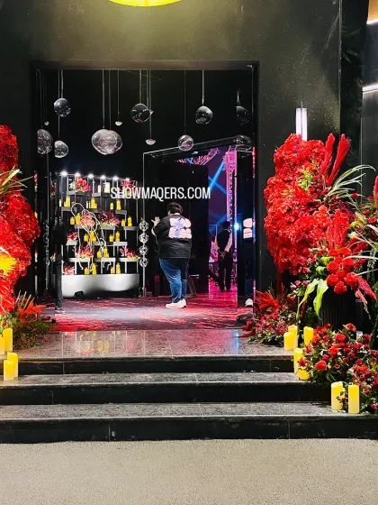 The entrance to a red and black themed cocktail party. Massive arrangements of red flowers and numerous candles line the steps, creating a powerful and passionate welcome.