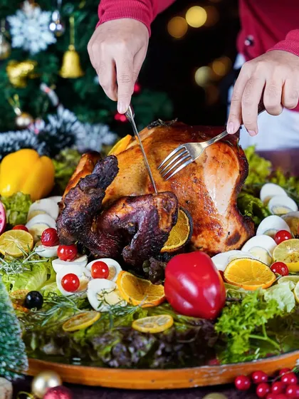 Hands carving a large roasted turkey for a Christmas dinner. This classic action shot evokes the tradition and centerpiece of a holiday family meal.