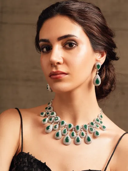 A contemporary diamond and emerald drop necklace, designed for the modern woman who loves a touch of classic glamour.
