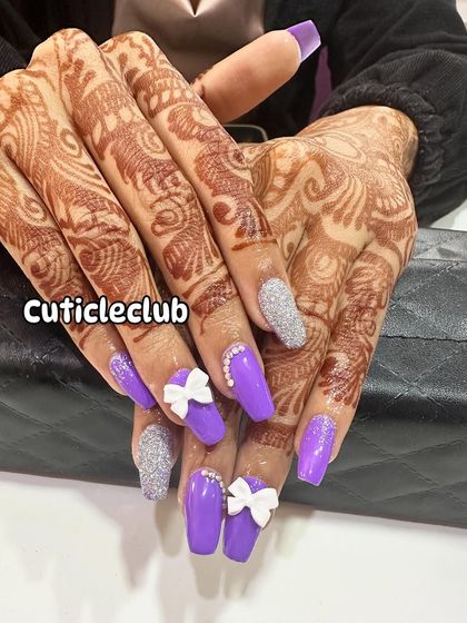 Perfect for an engagement or sangeet, this vibrant purple nail set is paired with silver glitter accent nails. The look is finished with cute 3D white bows and a line of rhinestones for extra flair.