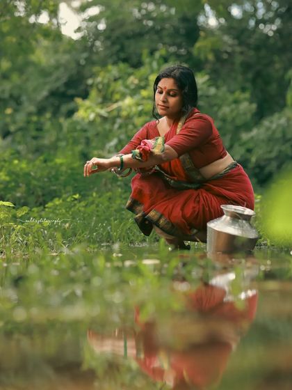 A rustic, village-themed series inspired by the movie 'Kanthara'. The model is styled in a simple red saree, captured in a natural, watery landscape to evoke a sense of raw, earthy beauty.