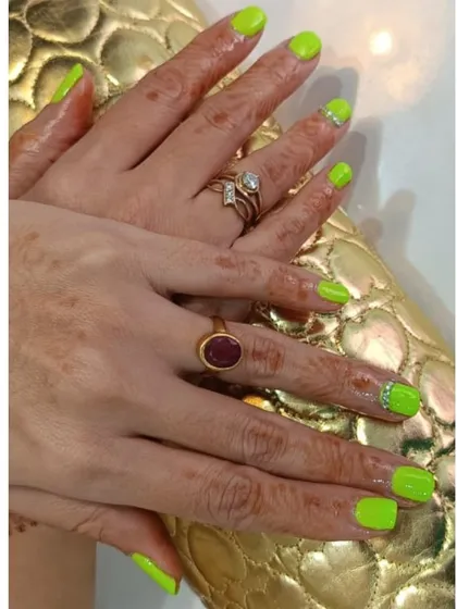 Go bold with this electrifying neon green manicure. Some nails feature a sparkling accent at the cuticle, adding a bit of extra flair to an already show-stopping color choice.