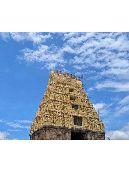 The magnificent gopuram of the Belur temple against a backdrop of fluffy white clouds. A testament to ancient Indian craftsmanship.